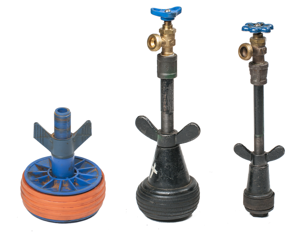 "Image of three open center test plugs, each featuring a valve at the top and designed with a central opening for pressure testing purposes."